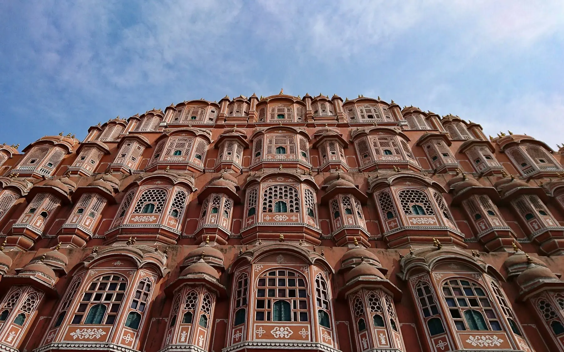 Looking up at Hawa Mahal's tiers of latticed windows against a blue sky
