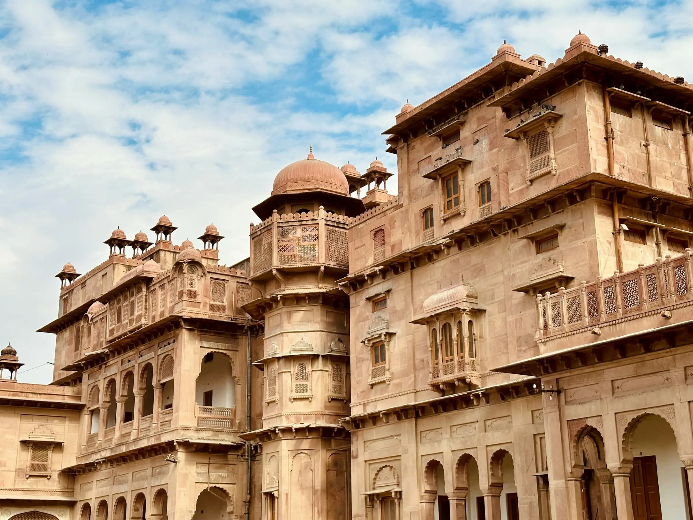 Red sandstone palace buildings with domed pavilions and carved balconies at Junagarh Fort, Bikaner