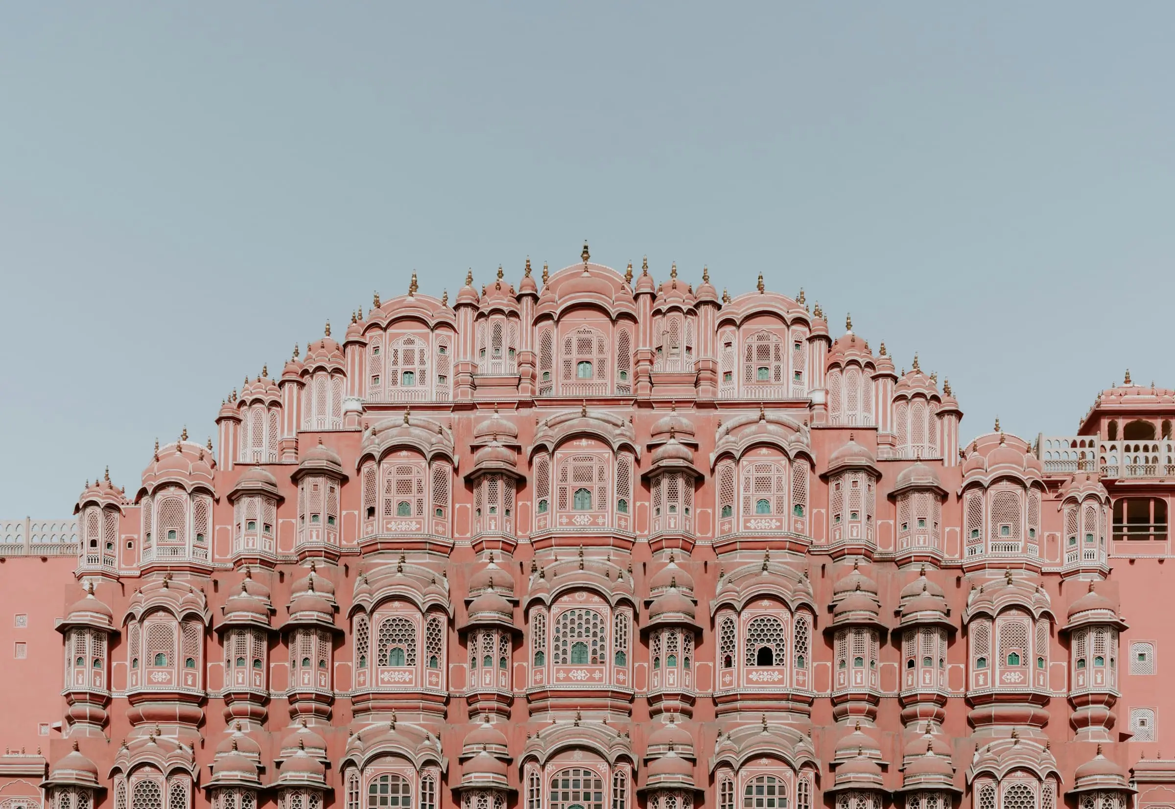 The pink sandstone façade of Hawa Mahal in Jaipur, with tiers of small latticed windows