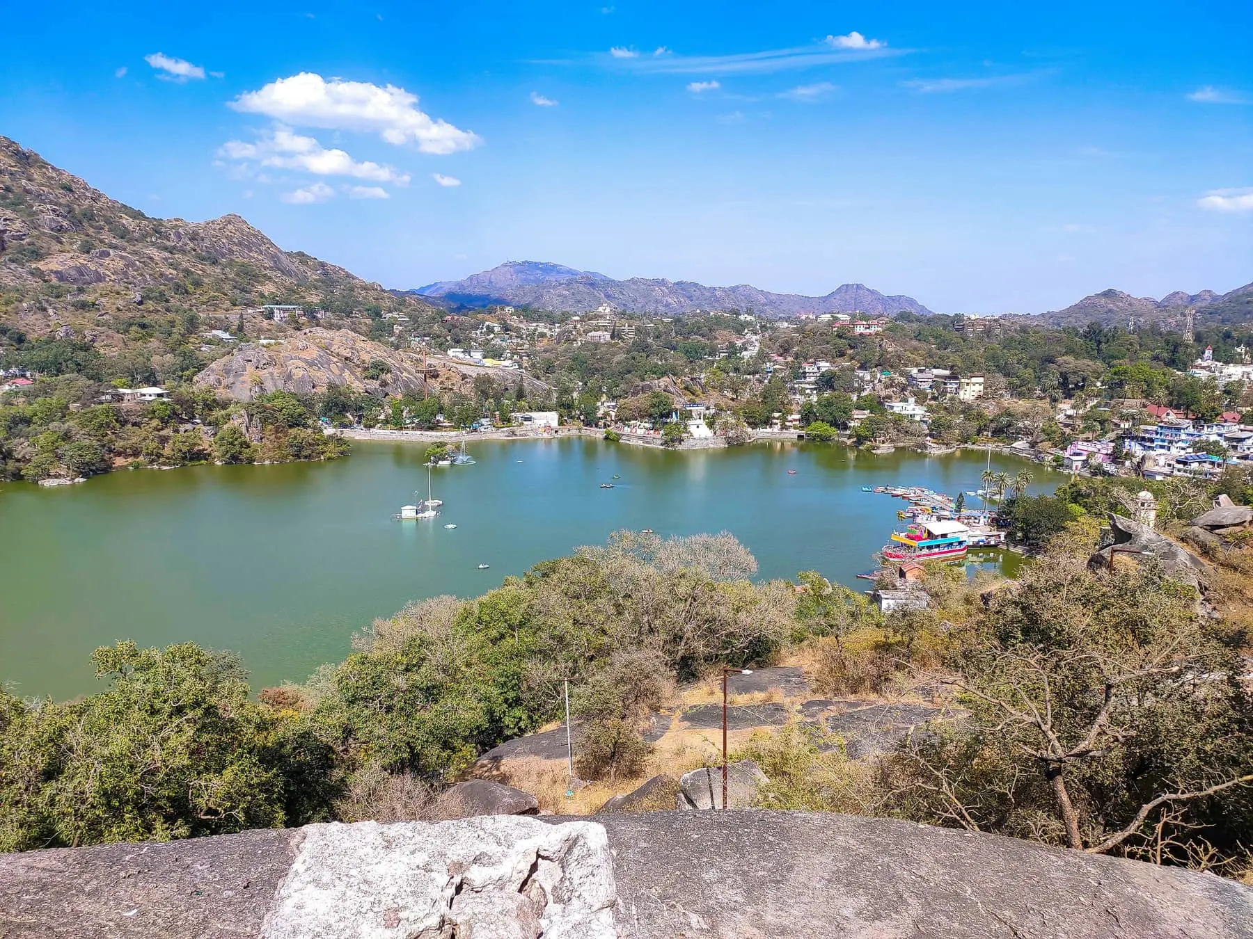 Nakki Lake at Mount Abu seen from rocks above, with the town and the Aravalli hills beyond